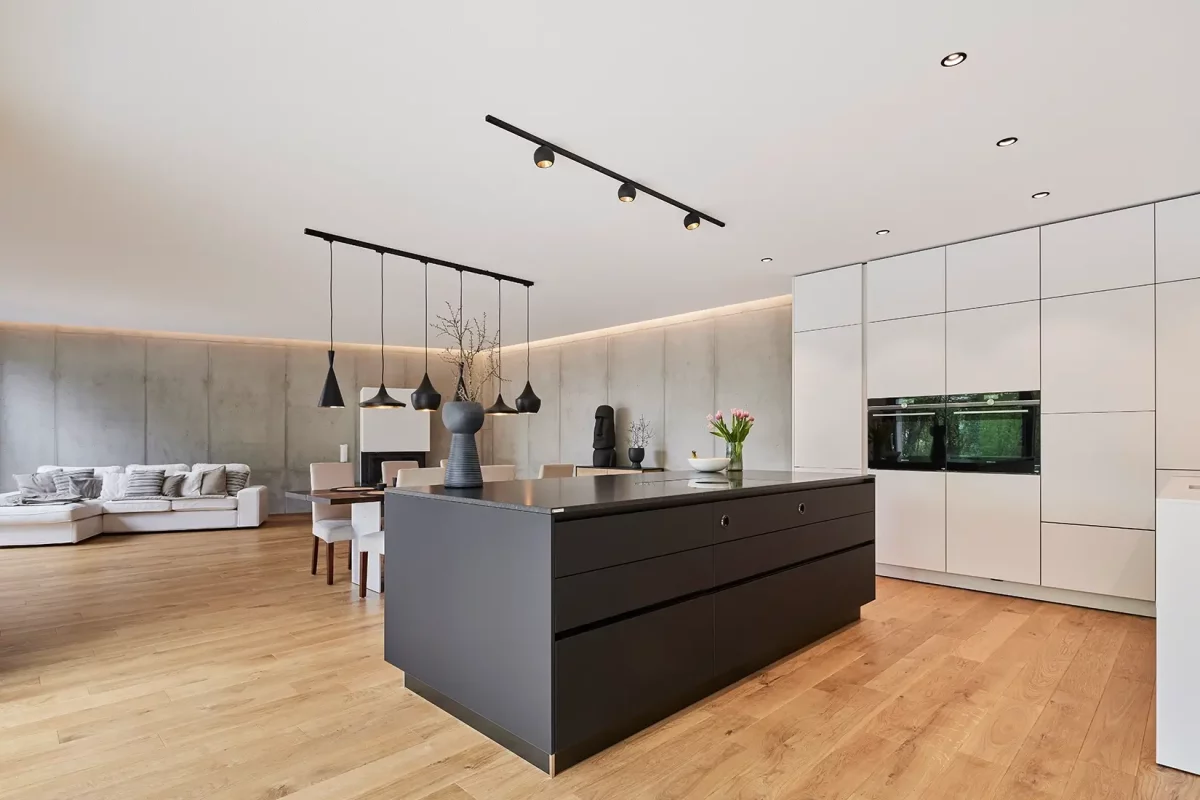 Die Küche mit Ihrem Materialmix aus hellen und dunklen Oberflächen geht nahtlos in den Wohnbereich über.