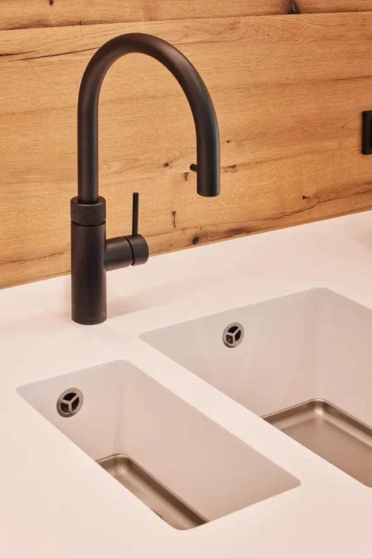 Die Corian Arbeitsplatte mit integriertem Spülbecken ist mit einer Quooker Armatur ausgestattet.